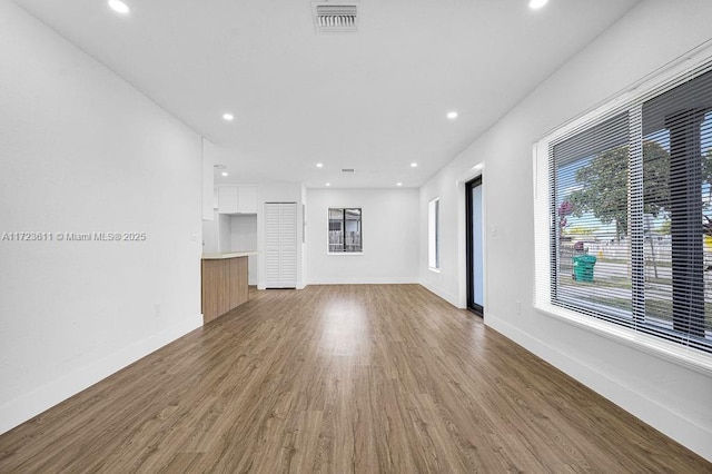 unfurnished living room with a wealth of natural light and hardwood / wood-style floors