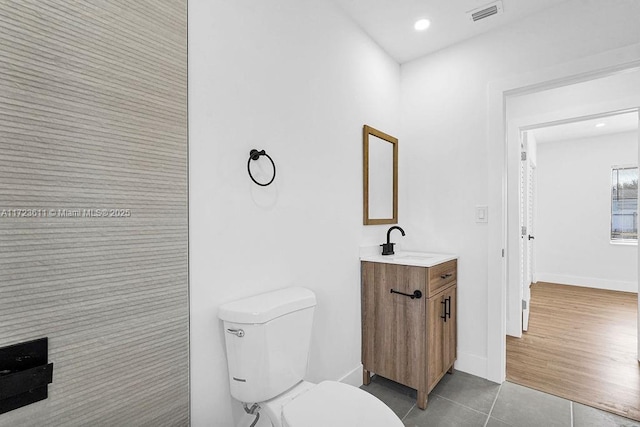 bathroom with toilet, vanity, and tile patterned floors