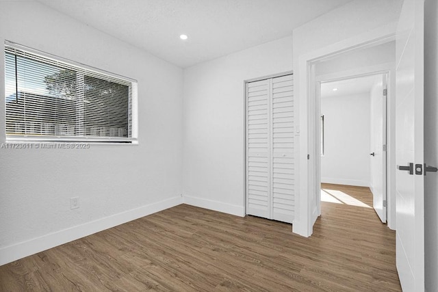 unfurnished bedroom featuring a closet and dark hardwood / wood-style floors