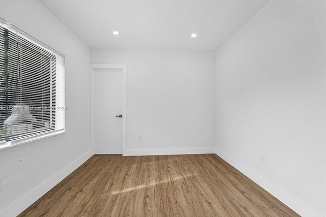 unfurnished room with hardwood / wood-style flooring