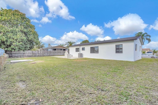 back of house featuring cooling unit, a yard, and a patio