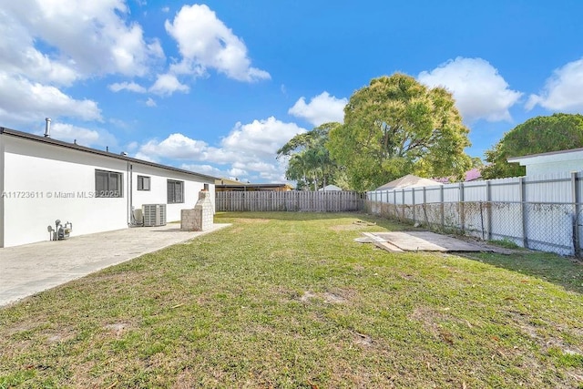 view of yard with central AC and a patio