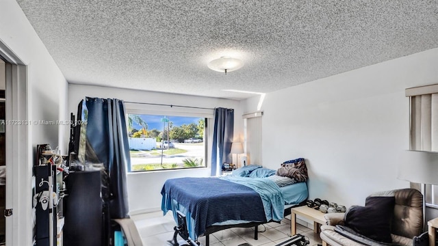 bedroom featuring a textured ceiling and light tile patterned floors