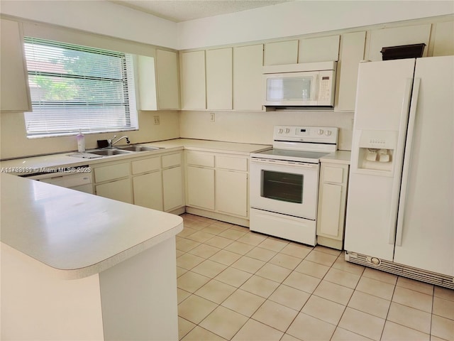 kitchen featuring cream cabinets, light countertops, a sink, and white appliances