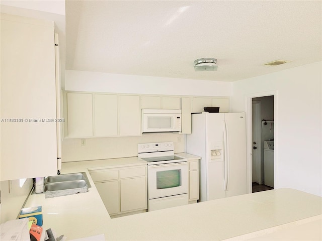 kitchen featuring light countertops, white appliances, washer / clothes dryer, a sink, and visible vents