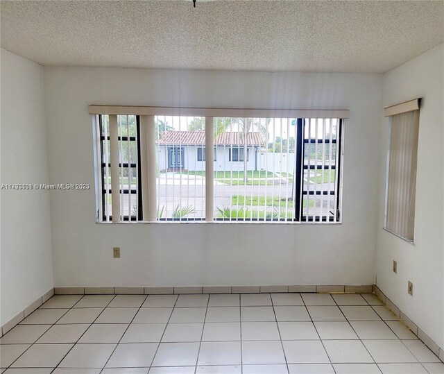 5205 SW 102nd Pl, Miami, FL 33165 - tiled empty room with baseboards and a textured ceiling
