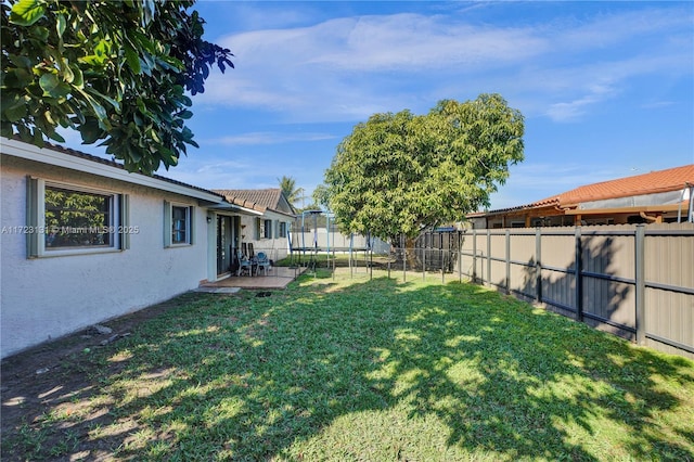 view of yard with a fenced backyard and a trampoline