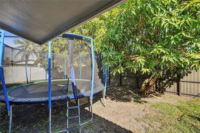 view of yard with a trampoline and a fenced backyard