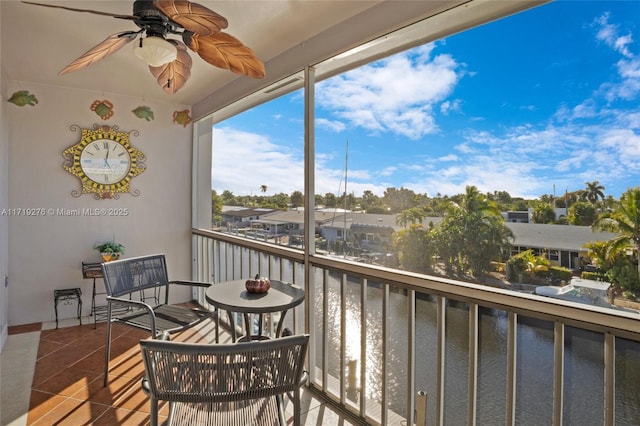 balcony with ceiling fan and a water view