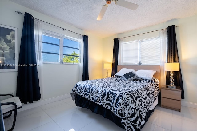 bedroom featuring light tile patterned floors, a textured ceiling, a ceiling fan, and baseboards