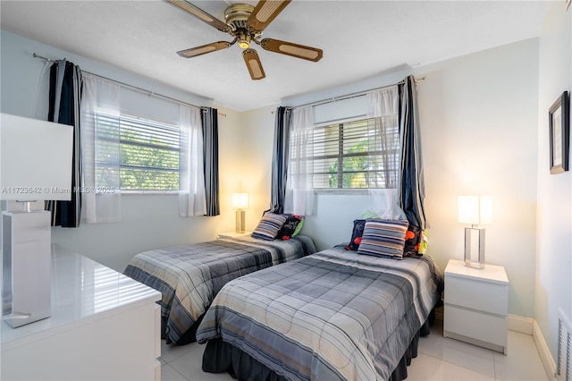 bedroom with light tile patterned floors, a ceiling fan, visible vents, and baseboards