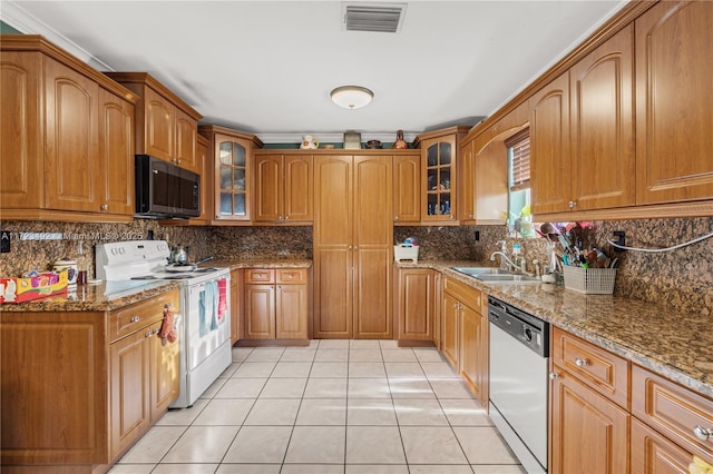 kitchen with sink, white appliances, stone counters, and light tile patterned flooring