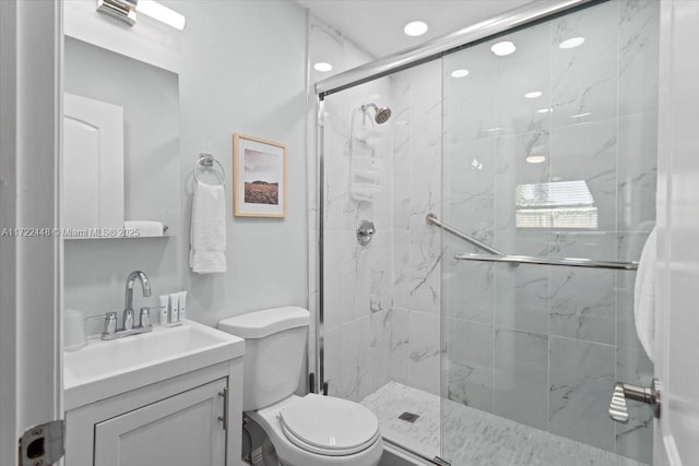 bathroom with vanity, toilet, and a shower with shower door