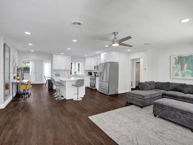 living room featuring ceiling fan and dark hardwood / wood-style flooring