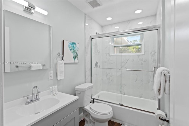 full bathroom with vanity, shower / bath combination with glass door, and toilet