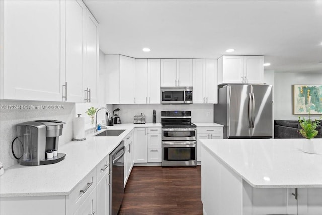 kitchen featuring appliances with stainless steel finishes, sink, dark wood-type flooring, and white cabinets