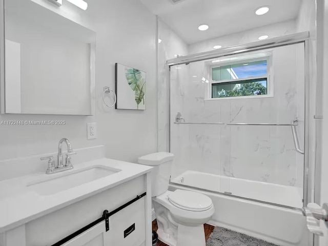 full bathroom featuring toilet, vanity, and shower / bath combination with glass door