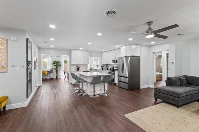 living room featuring dark wood-type flooring and ceiling fan