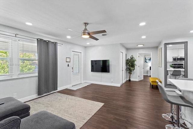 living room featuring dark hardwood / wood-style flooring and ceiling fan