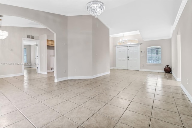 tiled entryway with a chandelier, lofted ceiling, and ornamental molding