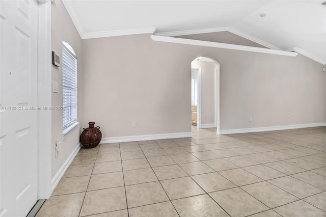 tiled spare room featuring crown molding, a wealth of natural light, and vaulted ceiling