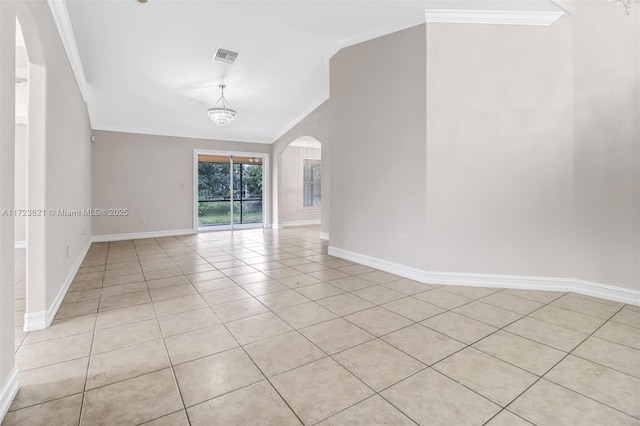 empty room featuring ornamental molding, light tile patterned floors, and an inviting chandelier