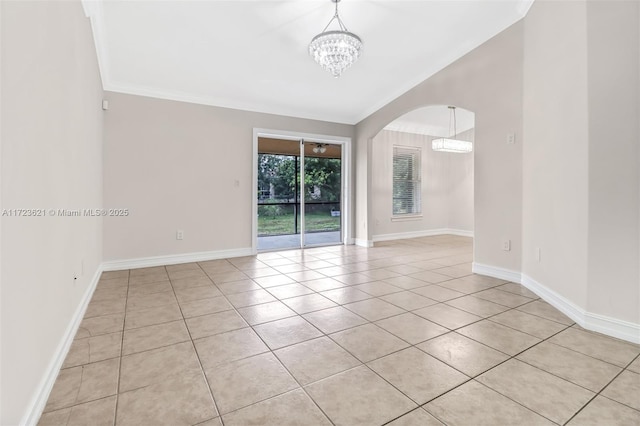 tiled spare room with crown molding and an inviting chandelier