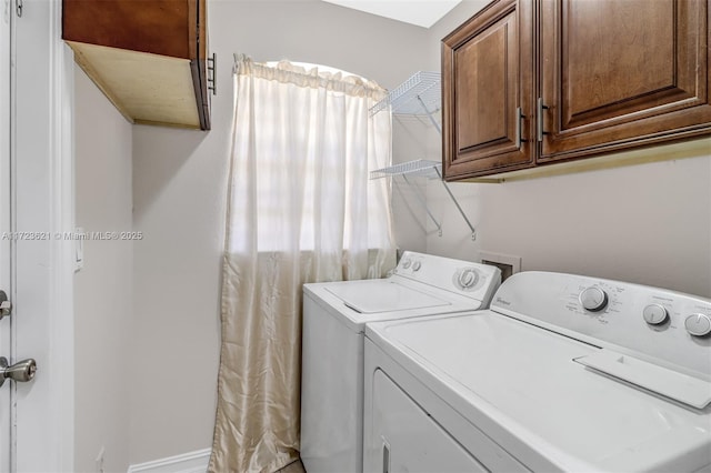 laundry area with washer and dryer and cabinets