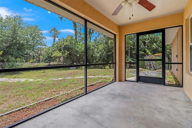 unfurnished sunroom featuring ceiling fan