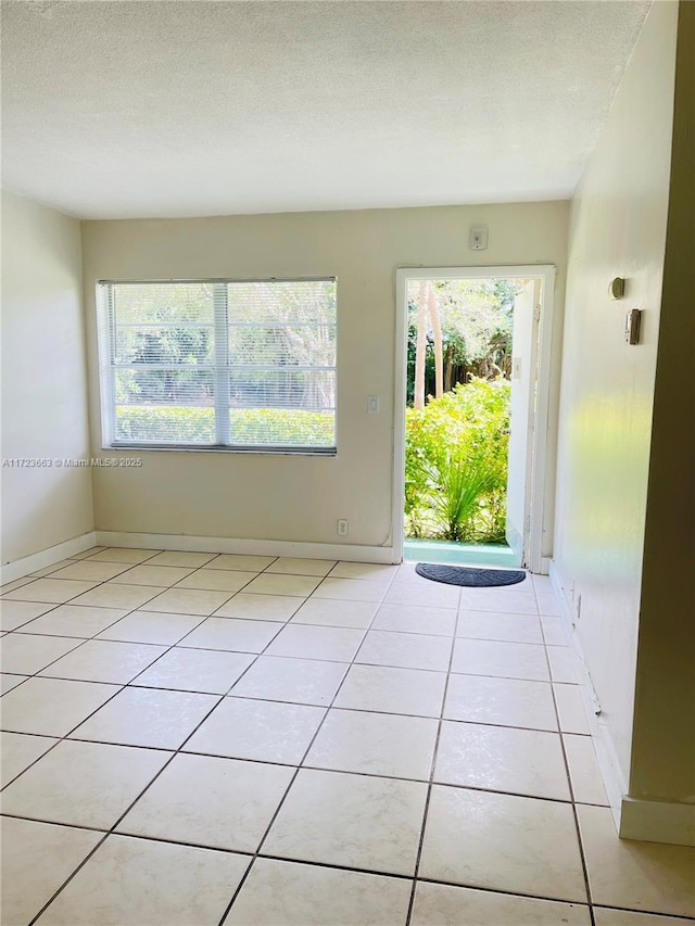 interior space featuring light tile patterned floors and a textured ceiling