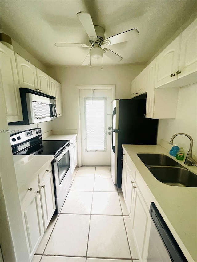 kitchen featuring white cabinets, sink, ceiling fan, light tile patterned floors, and appliances with stainless steel finishes