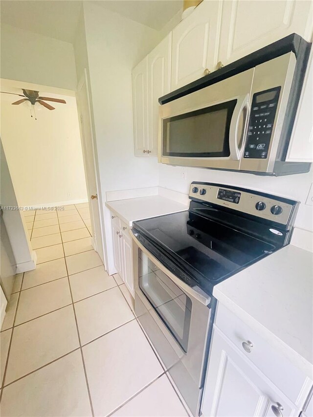 kitchen with ceiling fan, white cabinetry, light tile patterned flooring, and appliances with stainless steel finishes