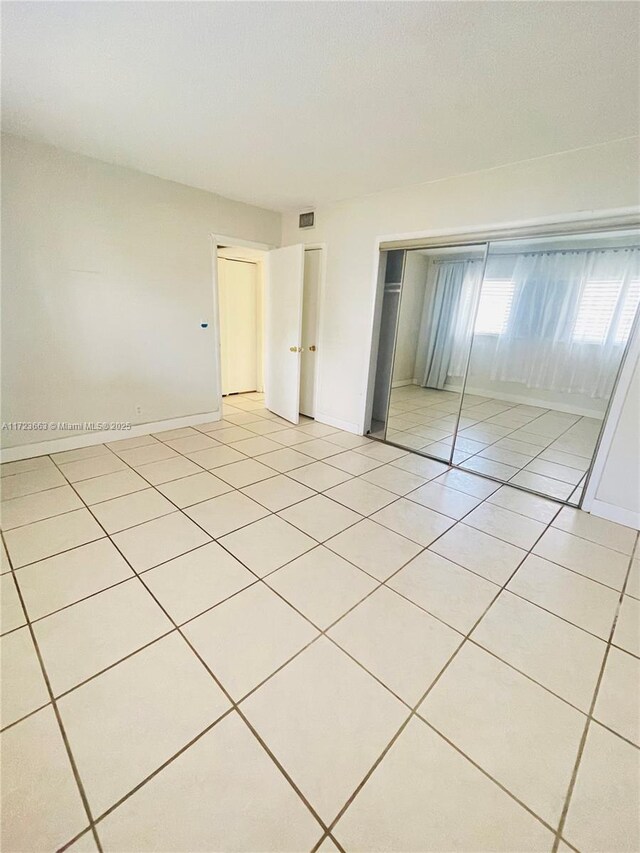 unfurnished bedroom featuring a closet and light tile patterned flooring