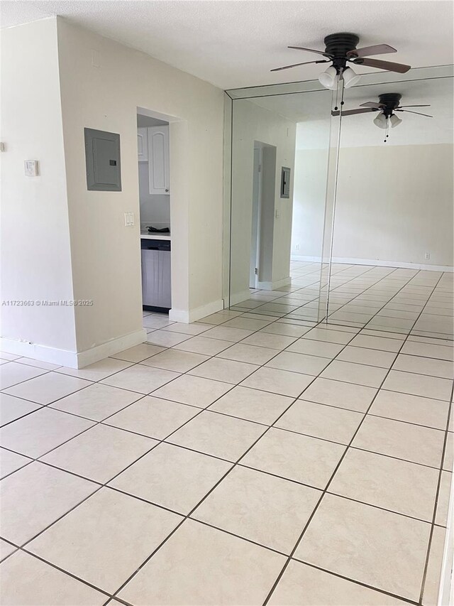 tiled empty room featuring a textured ceiling, electric panel, and ceiling fan