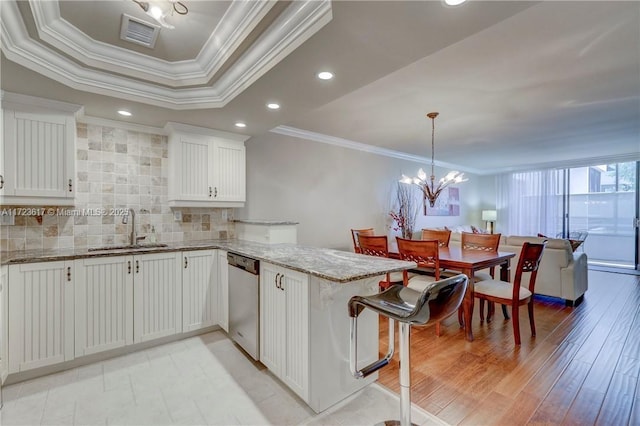 kitchen with sink, white cabinets, backsplash, stainless steel dishwasher, and kitchen peninsula