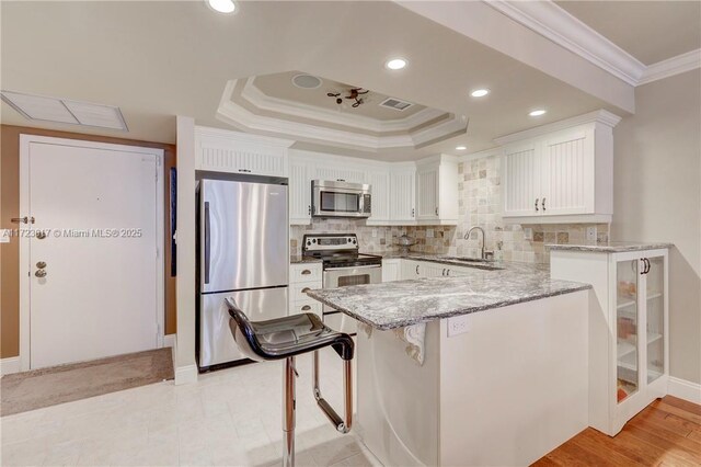 kitchen featuring kitchen peninsula, sink, dishwasher, white cabinetry, and hanging light fixtures