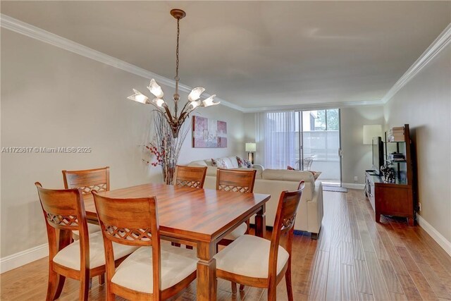 dining space featuring a chandelier, light hardwood / wood-style flooring, and ornamental molding