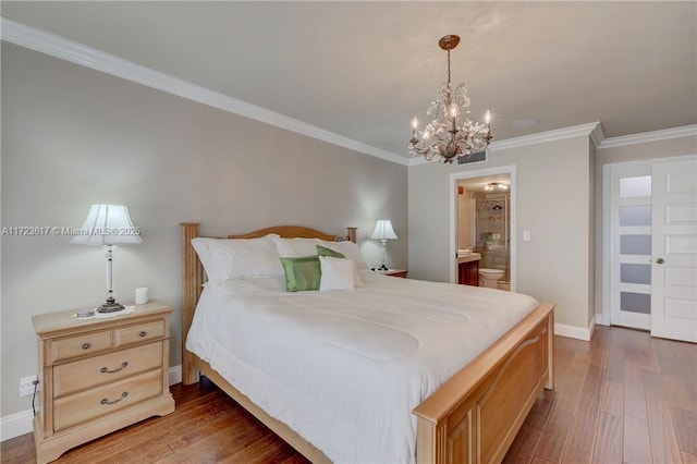 bedroom featuring ensuite bath, crown molding, a chandelier, and dark hardwood / wood-style floors