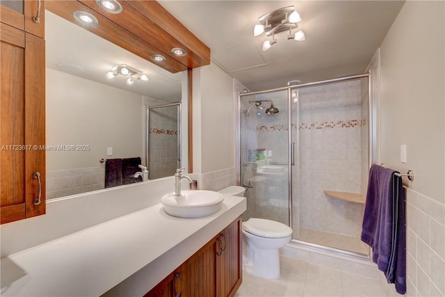 bathroom featuring tile patterned floors, vanity, toilet, and a shower with door