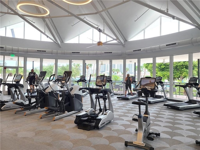 exercise room with carpet flooring, ceiling fan, and high vaulted ceiling