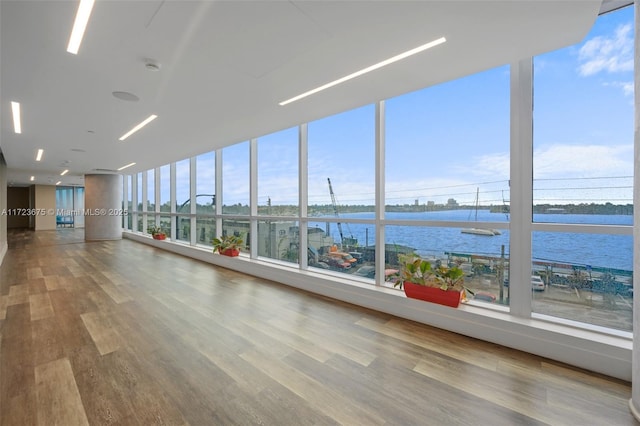 interior space with a water view and wood-type flooring