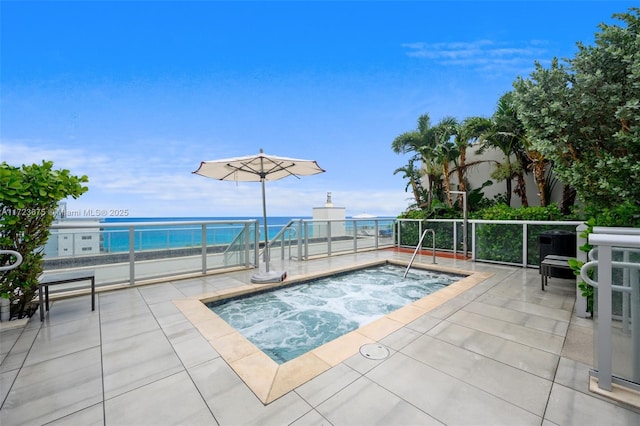 view of pool featuring an in ground hot tub, a patio, and a water view