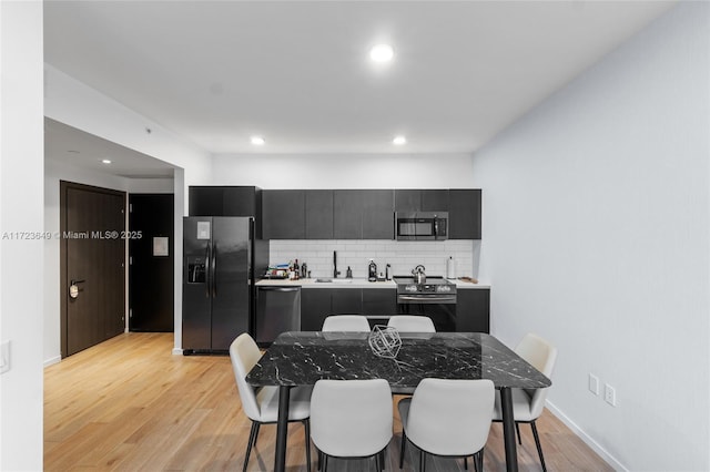 kitchen featuring a breakfast bar area, sink, appliances with stainless steel finishes, and tasteful backsplash