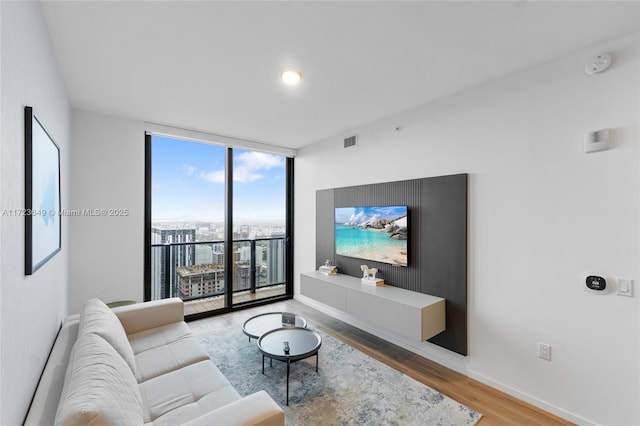 living room with expansive windows and hardwood / wood-style flooring