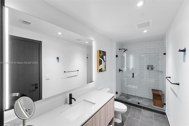 bathroom featuring tile patterned floors, toilet, vanity, and walk in shower