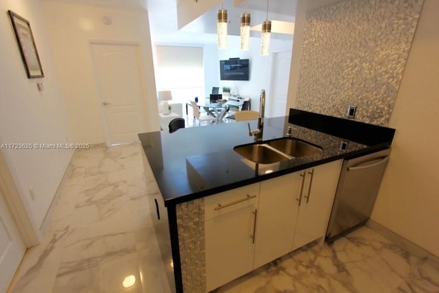 kitchen with dark stone counters, sink, hanging light fixtures, stainless steel dishwasher, and kitchen peninsula