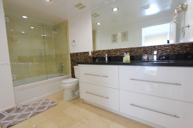 full bathroom featuring shower / bath combination with glass door, vanity, backsplash, and toilet