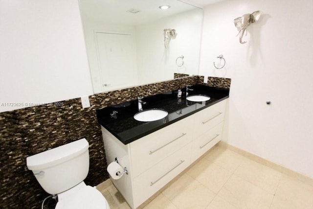 bathroom with tile patterned flooring, vanity, and toilet