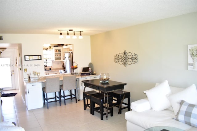 dining area with a textured ceiling and light tile patterned flooring