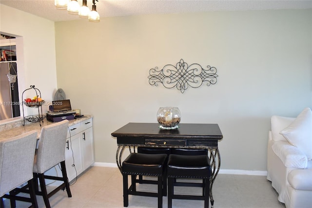 tiled dining area featuring a textured ceiling